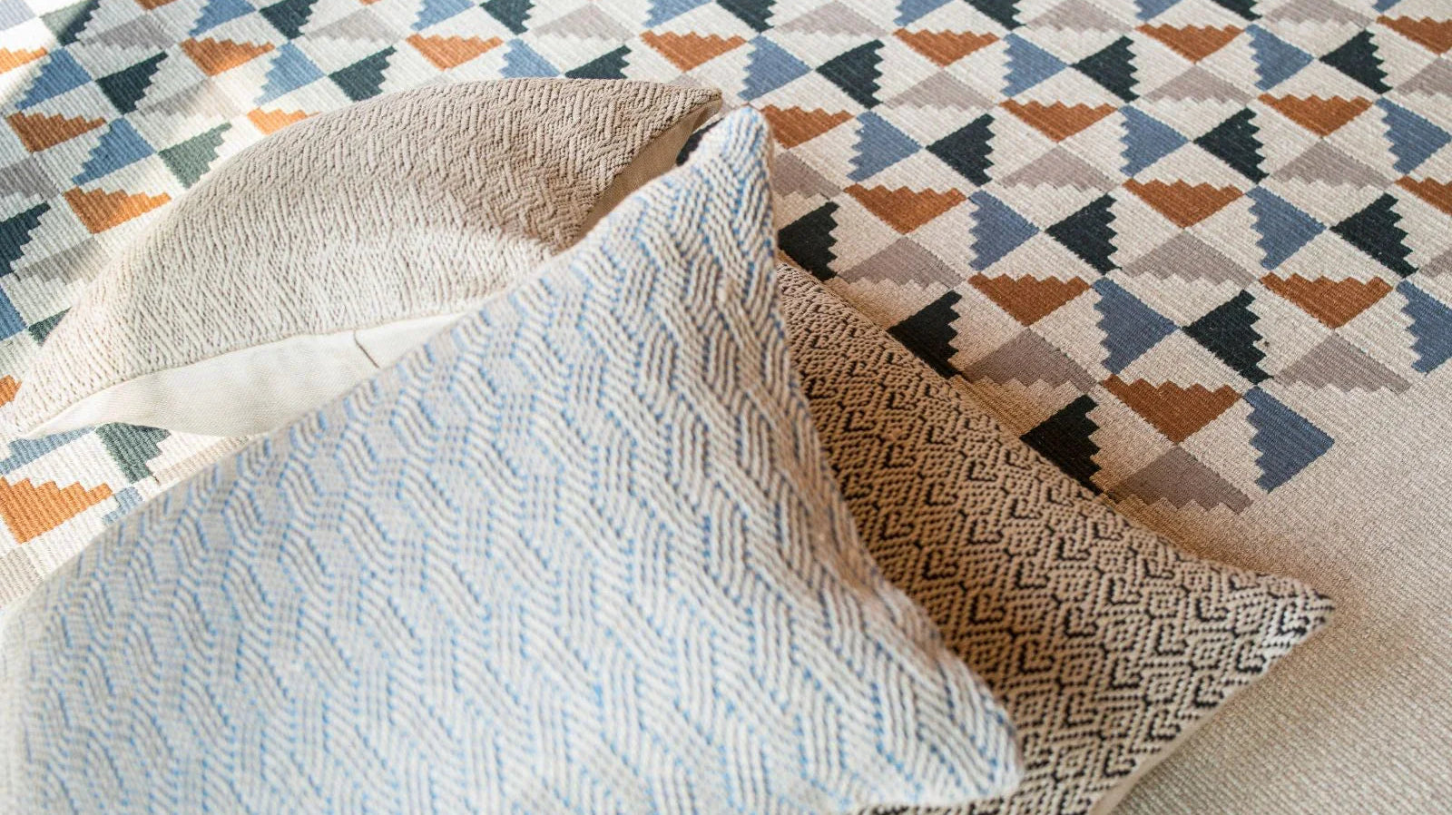 Turkish area rug with geometric pattern and textured cotton pillows on top