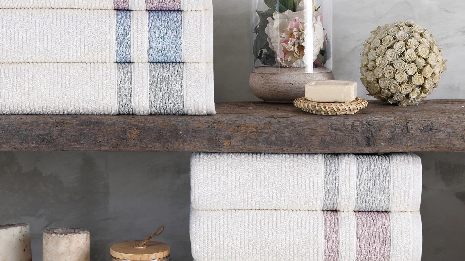 Stacked Turkish cotton towels with pastel stripes on wooden shelf, spa decor accents