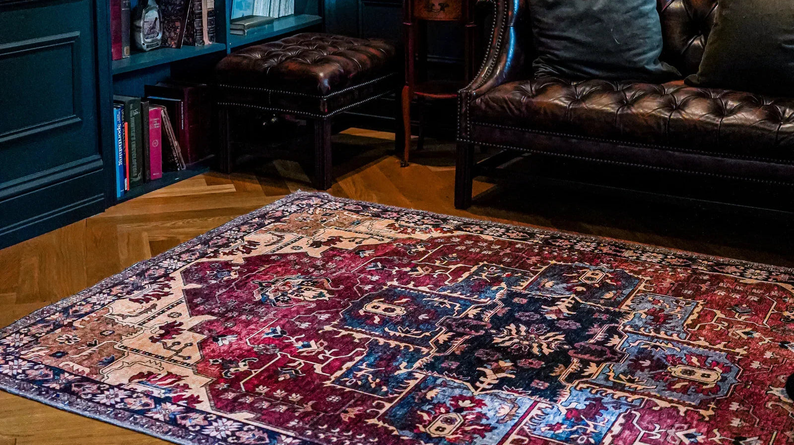 Colorful Turkish area rug with intricate pattern in cozy living room, near leather sofa and bookshelf.