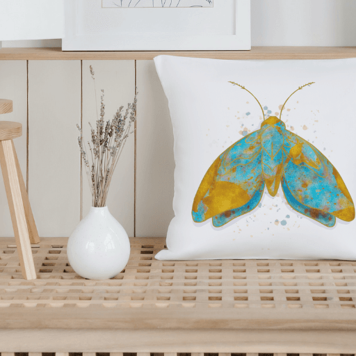 Stylish cotton pillow cover with vibrant moth design on a wooden bench, featuring sustainable materials and home decor elements.