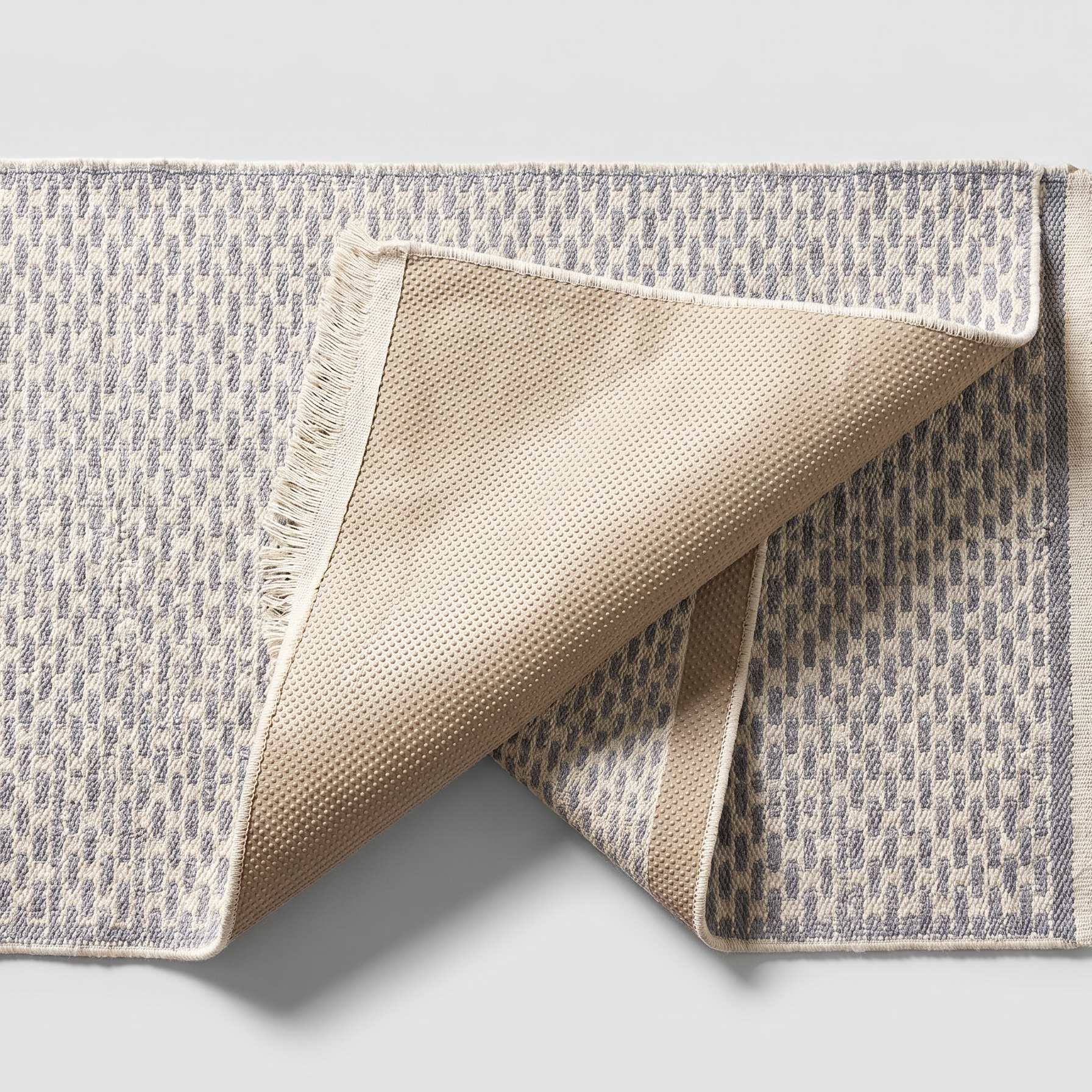 Underside of the light gray runner rug showing the silicone non-slip backing