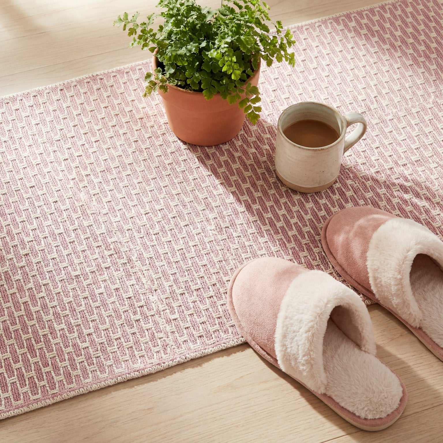 Overhead styled flat lay of the pink geometric check runner rug with home decor