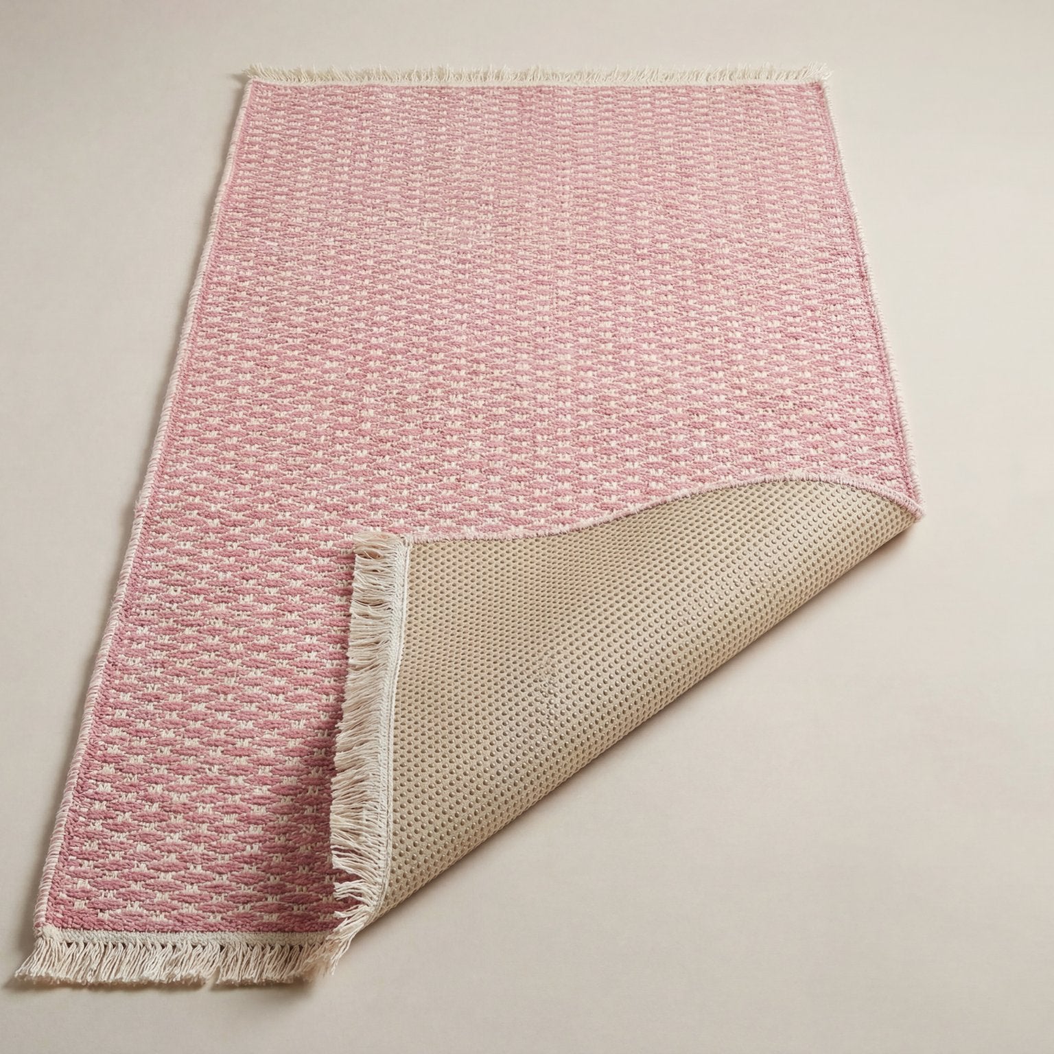 Underside of the pink runner rug showing the silicone non-slip backing