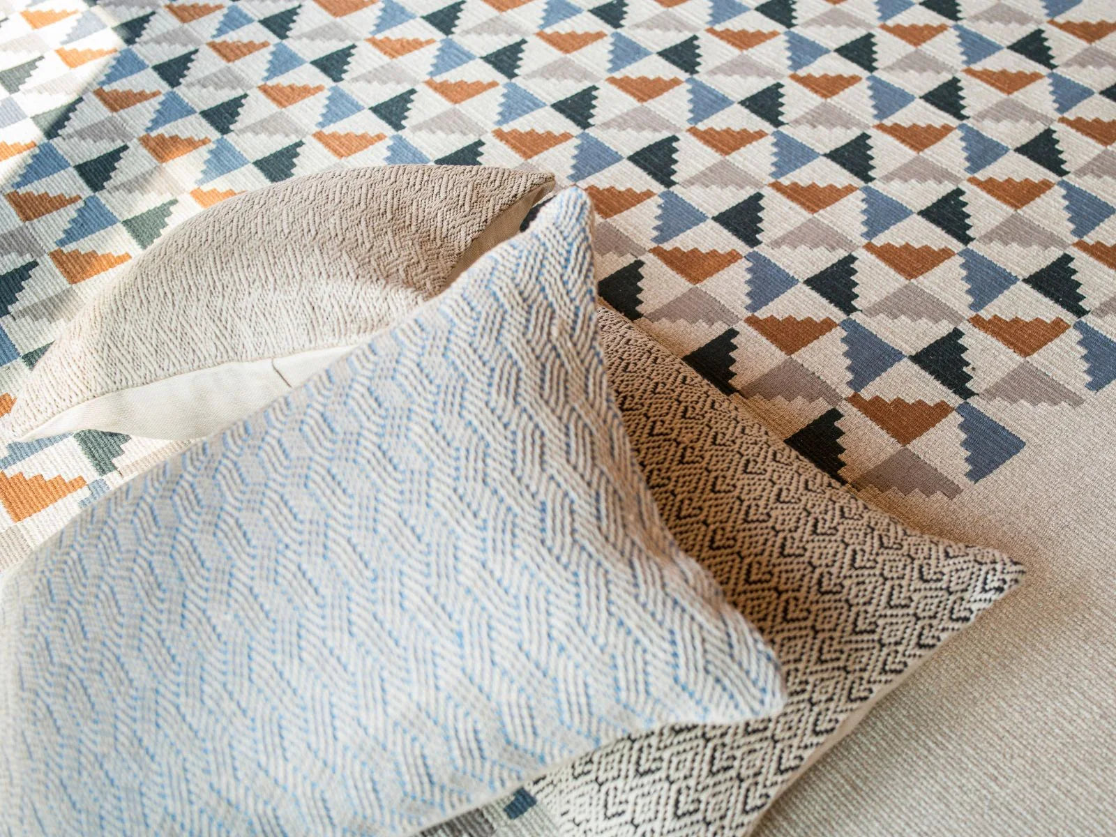 Turkish area rug with geometric pattern and textured cotton pillows on top