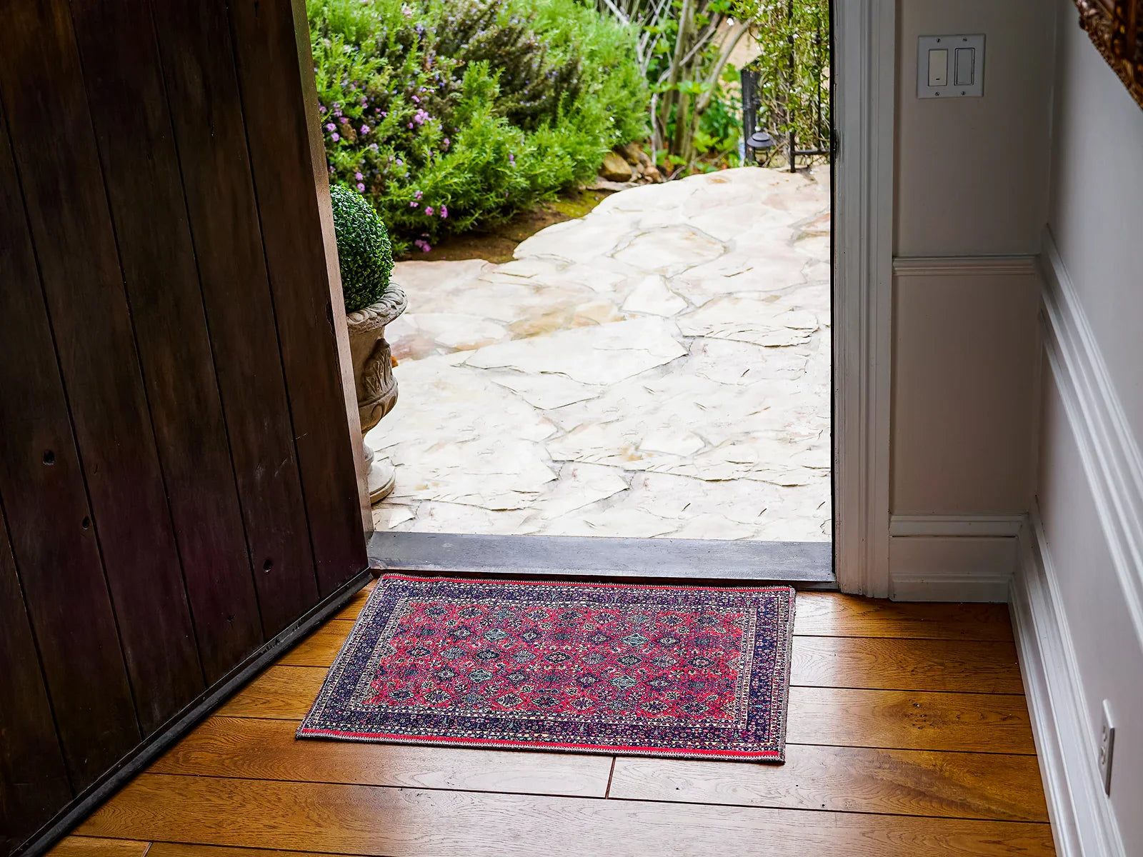 Turkish washable area rug in red pattern at entrance on hardwood floor with open door