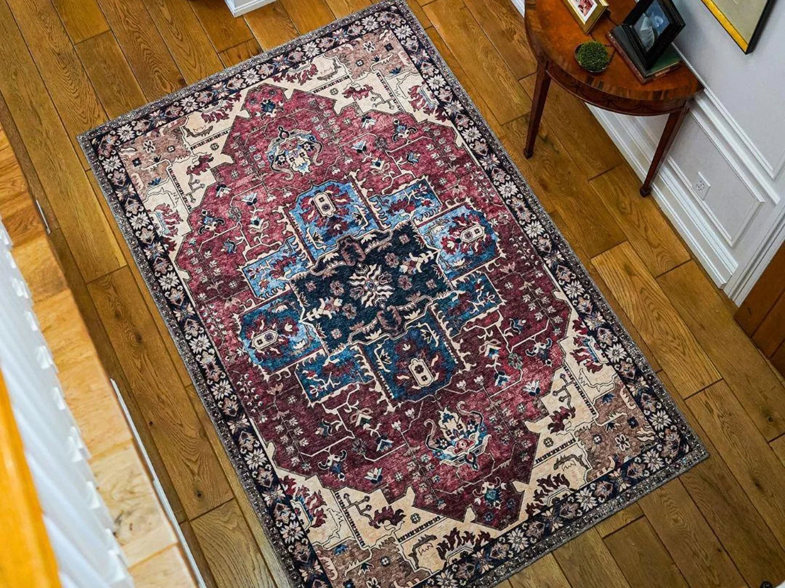 Traditional Turkish washable area rug with red, blue, and ivory patterns on wooden floor