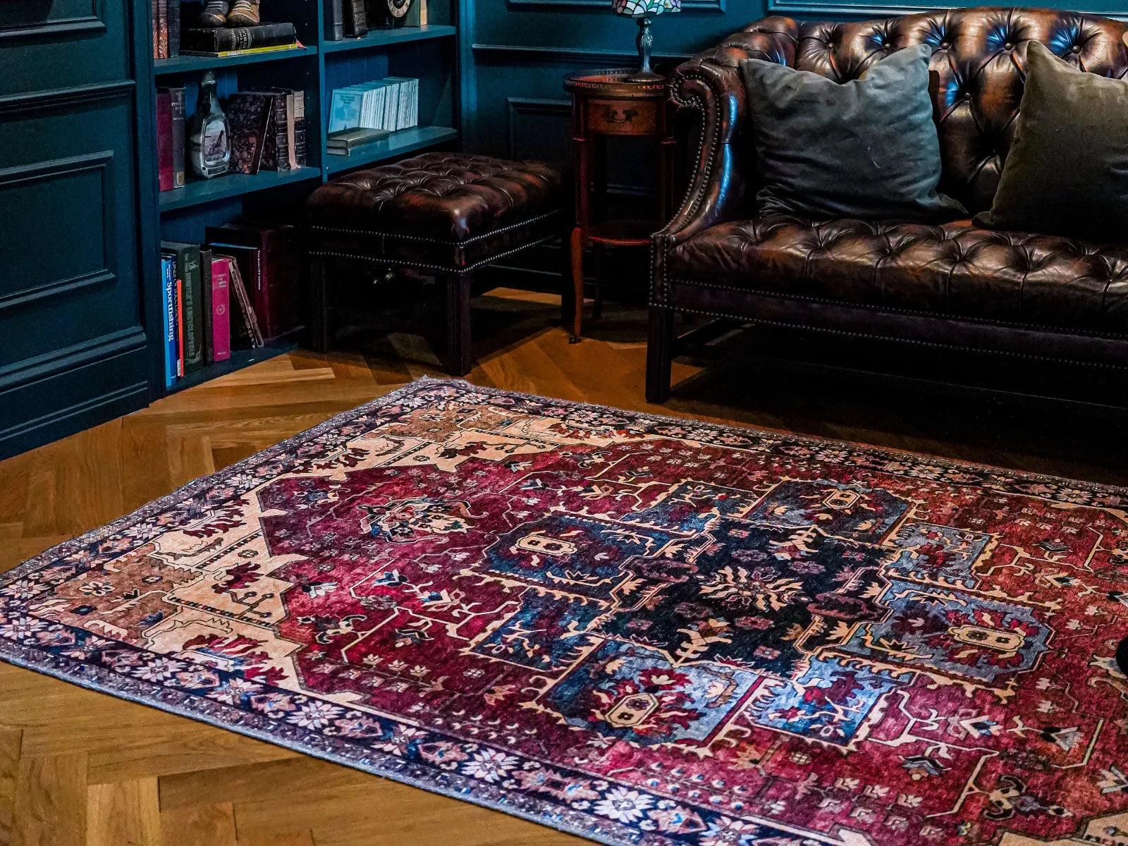 Colorful Turkish area rug with intricate pattern in cozy living room, near leather sofa and bookshelf.
