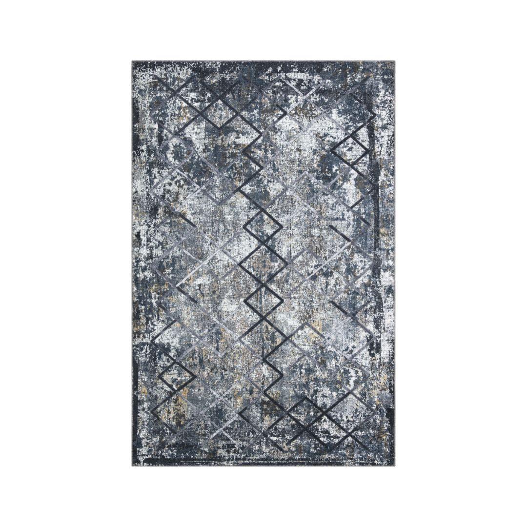 Low-pile geometric area rug layered over neutral carpet in a living room