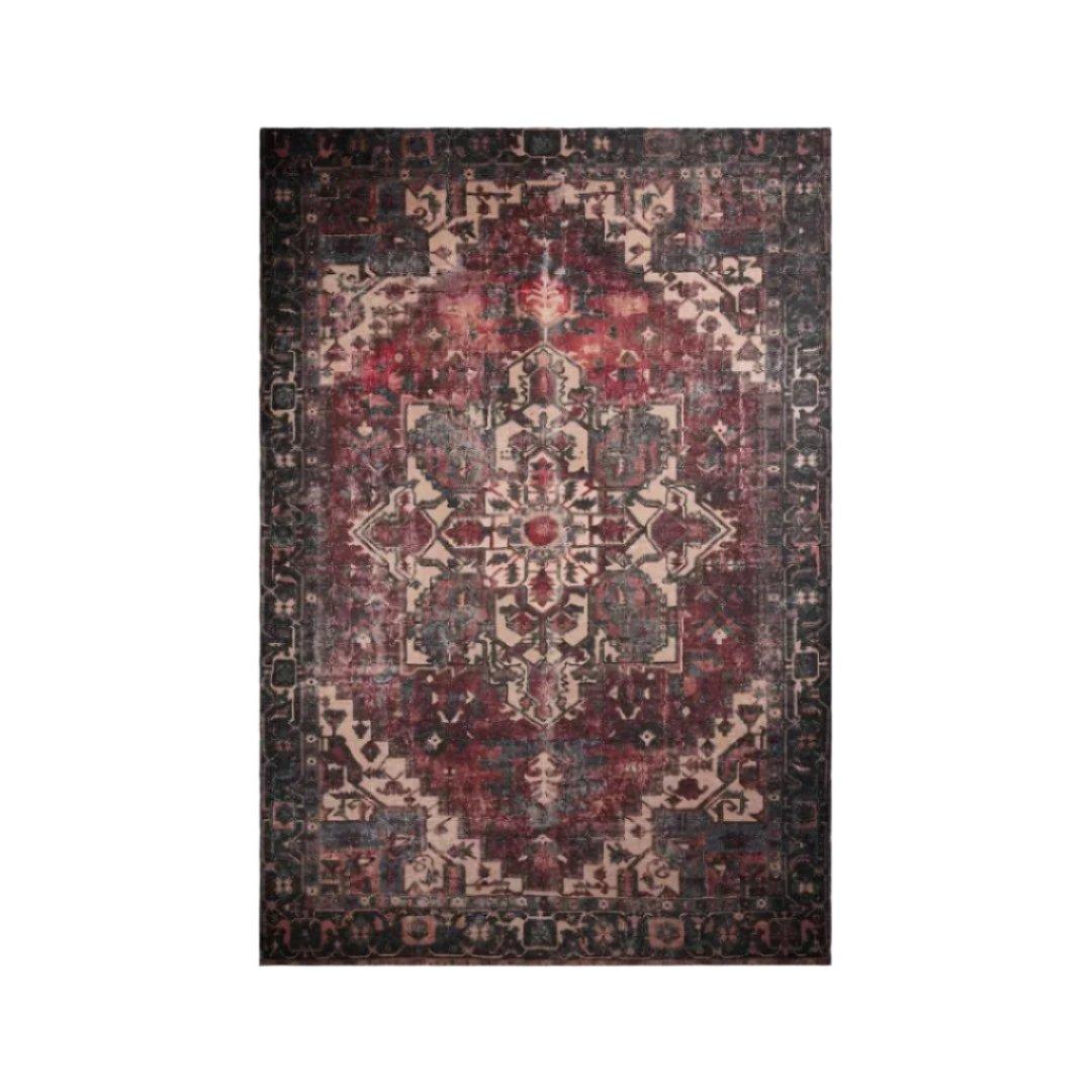 Burgundy vintage machine washable area rug folded beside a front-loading washing machine