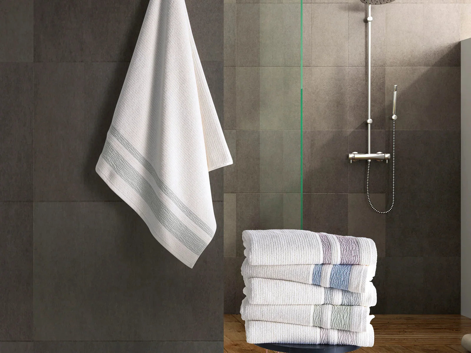 Stack of Turkish cotton towels with subtle stripes in modern bathroom setting