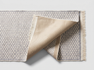 Underside of the light gray runner rug showing the silicone non-slip backing