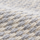 Close-up of the flat-woven kilim weave texture of the light gray geometric check rug