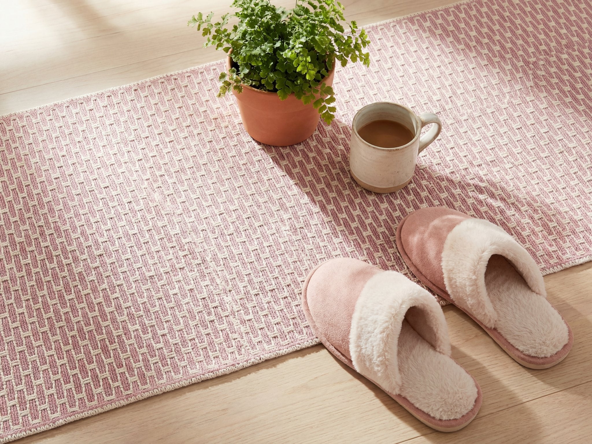 Overhead styled flat lay of the pink geometric check runner rug with home decor