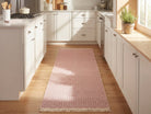 Pink geometric check washable runner rug on wood floor in a modern kitchen