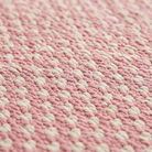 Close-up of the flat-woven kilim weave texture of the pink geometric check rug